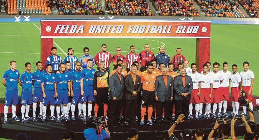 IRFAN (tengah) bersama barisan pemain, pegawai FELDA United pada majlis pengenalan dan pelancaran jersi pasukan di STAR, Jengka.