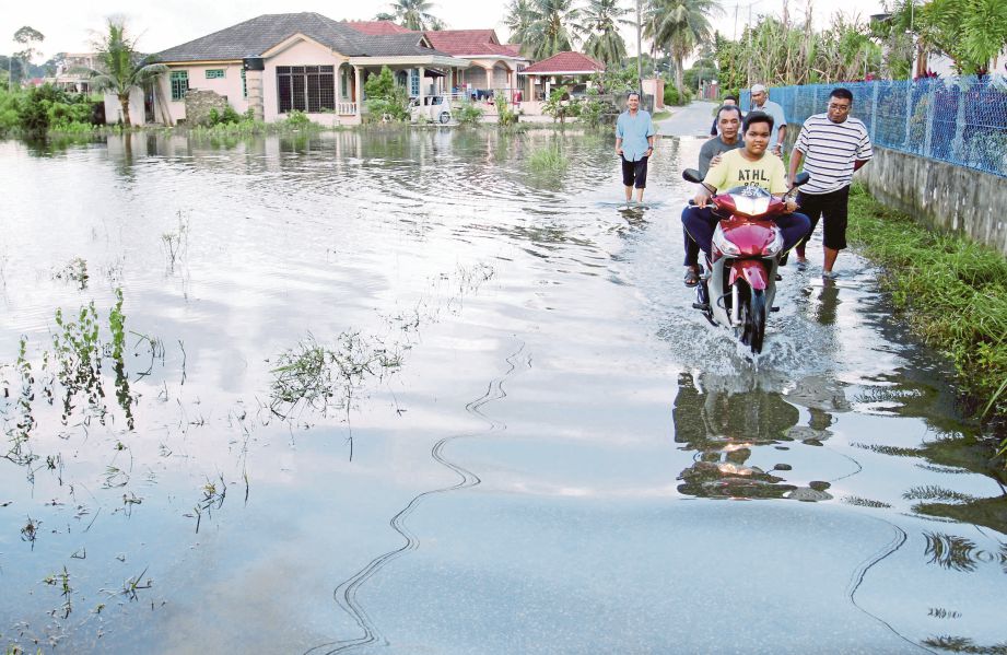 BEBERAPA penduduk di Kampung Pasir Hor, Kota Bharu mengharungi air banjir.