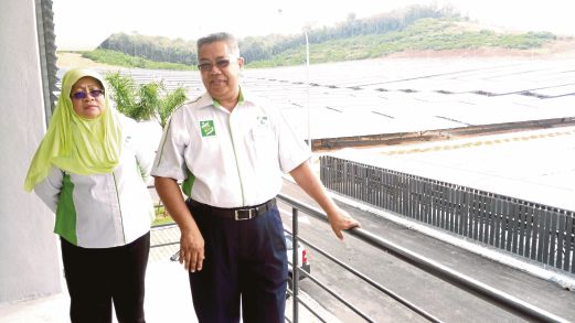 GUNTOR  (kanan) bersama Pengarah Eksekutif  Ganding Kencana Datin Hasnah menunjukkan  ladang panel solar milik syarikatnya.