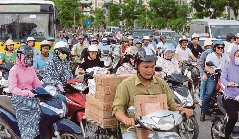 PULUHAN penunggang motosikal memenuhi salah satu jalan raya di Hanoi. - AFP 