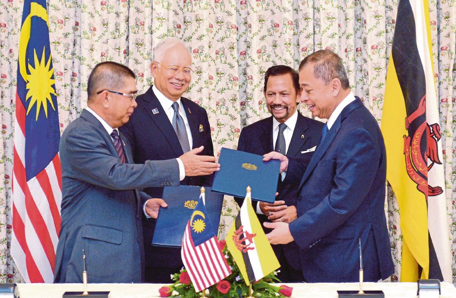 Sultan Hassanal Bolkiah   dan Najib  menyaksikan  pertukaran dokumen MoU antara  Dr Maximus (kiri)  dan Datu Mohammad di Bangunan Perdana Putra, semalam.