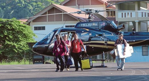 Pegawai SPR menurunkan kotak undi dari helikopter ketika tiba di Lapangan Terbang Pulau Tioman, semalam. 