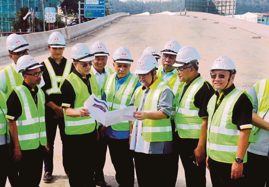 FADILLAH (depan, dua dari kiri) mendengar  penerangan Pengarah Jabatan Kerja Raya Pahang, Datuk Abdul Jalil Mohamad ketika meninjau projek pembinaan  laluan bertingkat di Jalan Bukit Ubi. 