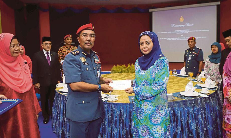 RAJA Zarith Sofiah menyampaikan cek sumbangan daripada  Sultan Ibrahim  kepada Yahaya  di  Ibu Pejabat Jabatan Bomba dan Penyelamat Johor, semalam.