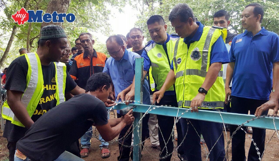KETUA Polis Kedah Datuk Asri Yusoff (dua dari kanan) memantau kerja memasang kawat berduri pada lorong haram berhampiran belukar yang sering digunakan penagih dadah di Kampung Bukit Malut, Langkawi, hari ini. FOTO Hamzah Osman