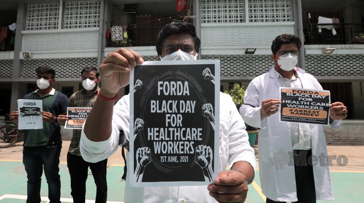 Ribuan doktor di India memakai lilitan hitam pada lengan sebagai bantahan terhadap individu yang mendakwa yoga dapat menghalang jangkitan Covid-19. FOTO AFP