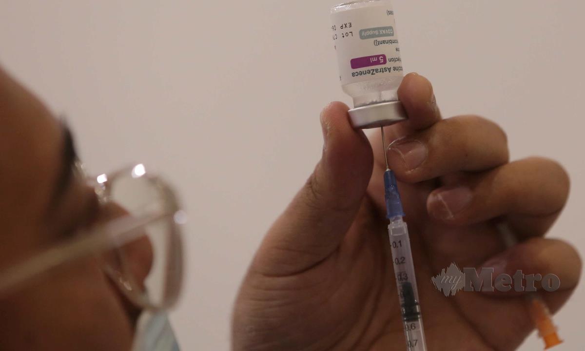 Petugas kesihatan memasukkan cecair vaksin COVID-19. FOTO MUHD ASYRAF SAWAL