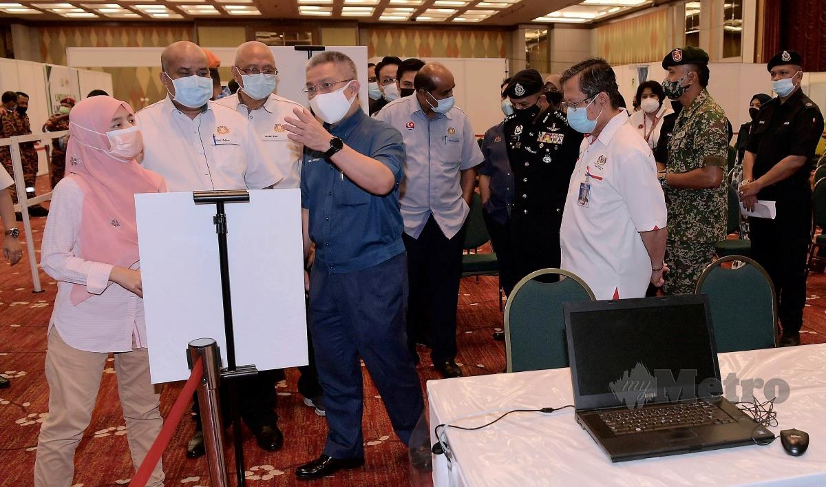 Menteri Kesihatan Datuk Seri Dr Adham Baba (empat, kiri) mendengar penerangan ketika meninjau Pusat Pemberian Vaksin (PPV) Mega di Pusat Konvensyen Antarabangsa Persada hari ini.  FOTO BERNAMA