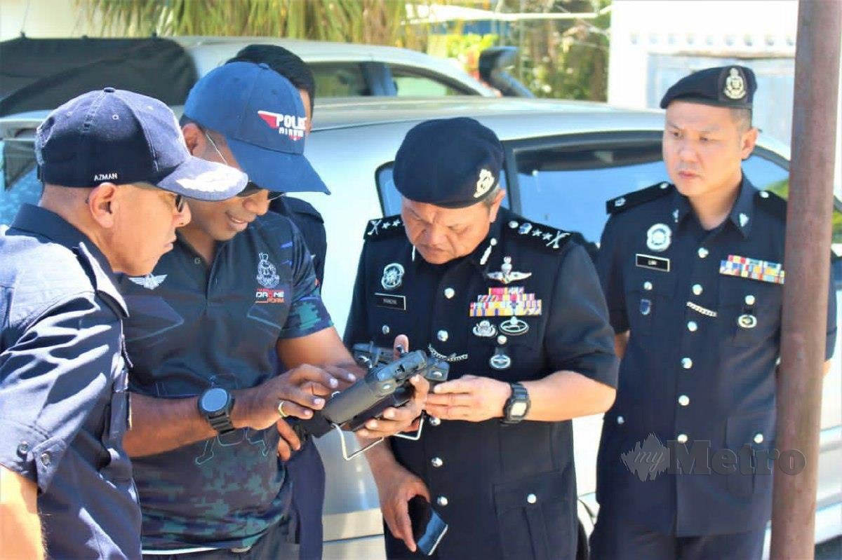 Pesuruhjaya Polis Sarawak Datuk Mohd Azman Ahmad Sapri (kiri) melihat Unit Dron Pasukan Gerakan Udara (PGU) membuat pemantauan menggunakan dron bagi mengesan kedua-dua tahanan Indonesia yang lolos dari lokap Balai Polis Tapah, hari ini. FOTO MELVIN JONI