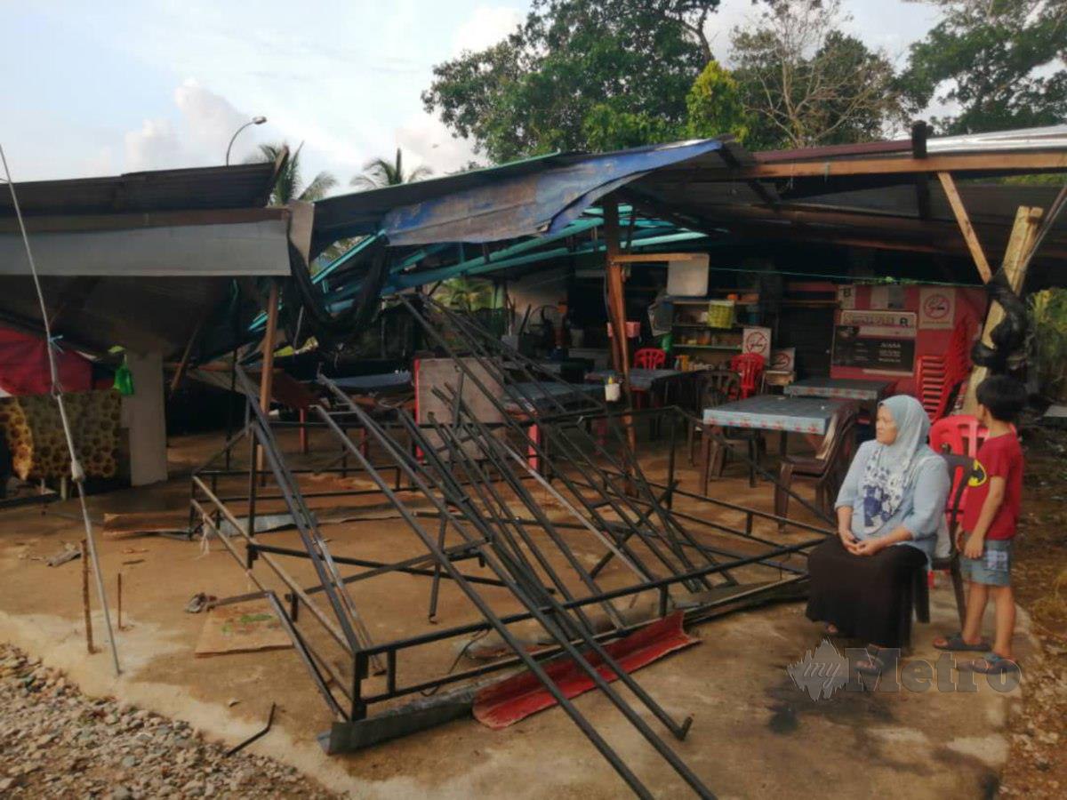 awiyah Muda, 63, melihat kedainya yang rosakan selepas dilanda ribut. FOTO NAZDY HARUN