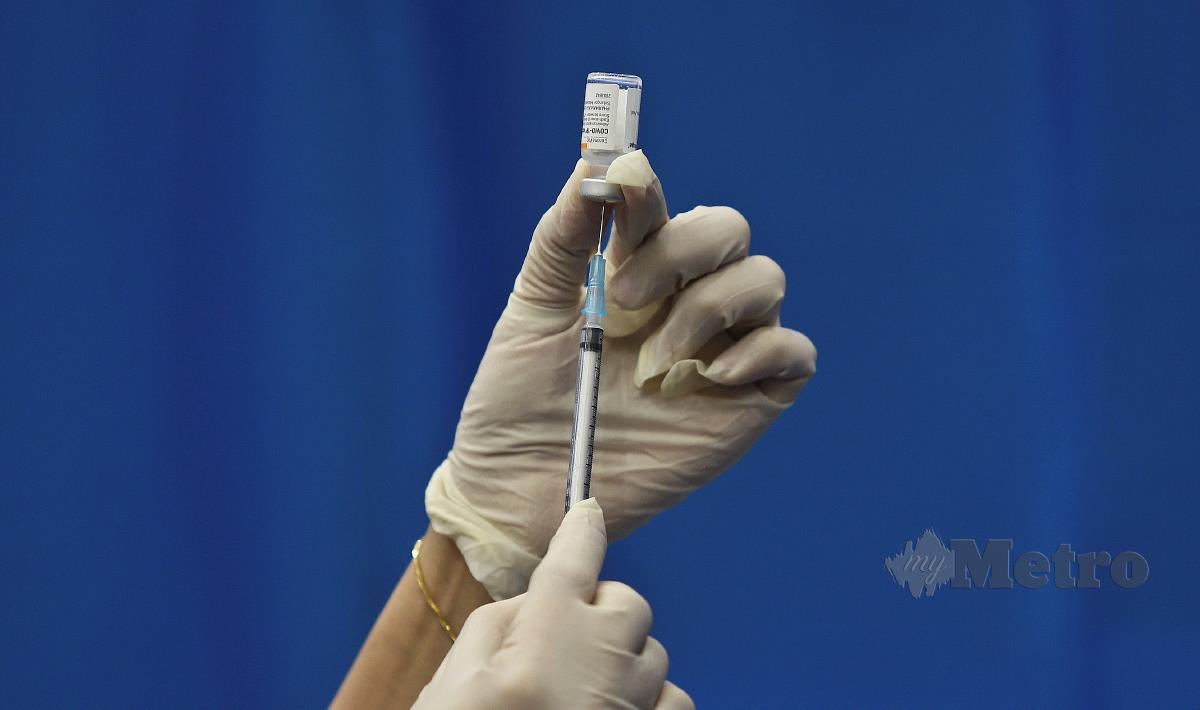Petugas kesihatan memasukkan cecair vaksin jenis Sinovac sebelum membuat suntikan vaksin COVID-19 kepada penerima vaksin. FOTO GHAZALI KORI 