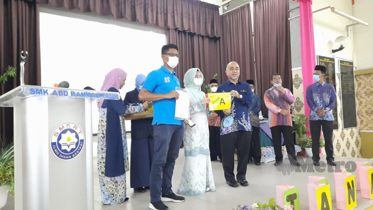 Pengarah Jabatan Pendidikan Negeri (JPN) Pahang, Mohammad Rosli Abdul Rahman menyampaikan slip keputusan Sijil Pelajaran Malaysia (SPM) 2021 kepada calon di Sekolah Menengah Kebangsaan (SMK) Abdul Rahman Talib, Kuantan. FOTO Asrol Awang