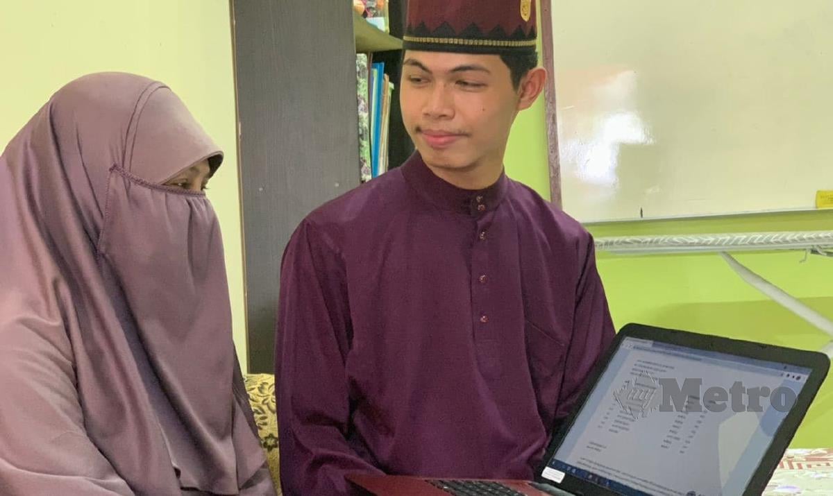 Muhammad Hanzalah Md Yusoff, 19, menunjukkan keputusan STAM kepada ibunya, Roslina Abdullah, 53 di Seri Manjung, Manjung. FOTO NOOR HIDAYAH TANZIZI