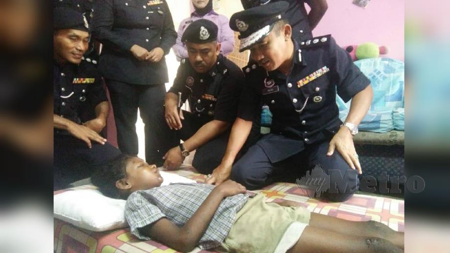 KETUA Polis Daerah Kuala Muda, Asisten Komisioner, Adzli Abu Shah, (kanan) berbual dengan kanak-kanak yang dilanggar dalam insiden pergaduhan di Flat Paya Nahu Ahad lalu, ketika melawat mangsa di rumahnya. FOTO Nor Farhani Che Ad