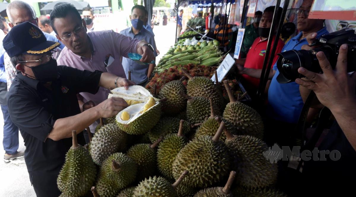 Timbalan Menteri Pertanian dan Industri Makanan 1, Datuk Seri Ahmad Hamzah (kiri) melihat durian Musang King yang dijual pada Program 'Fruit, Flower and Food Fiesta' (FamaFest) Pulau Pinang di Tapak Parkir Pasaraya Lotus's Seberang Jaya. FOTO DANIAL SAAD