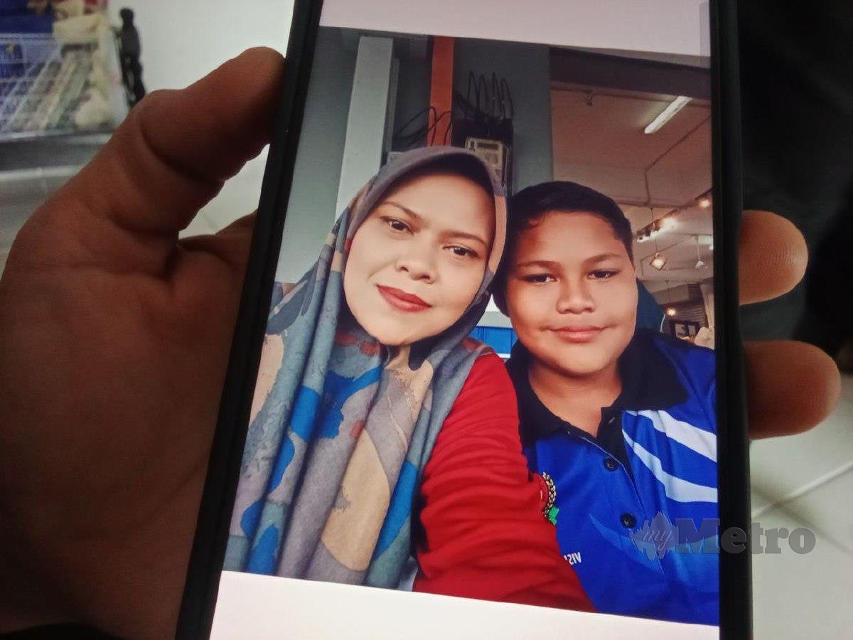 Nik Nurhayati Nik Mohd Marzuki menunjukkan gambar anaknya Muhammad Danish Darwish Dasuki Muhammad Adam yang hilang dari asrama sekolahnya sejak 9 Jun lalu. FOTO ABNOR HAMIZAM ABD MANAP