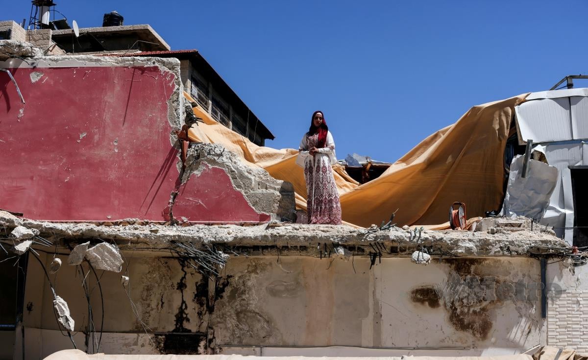 PENGANTIN wanita Palestin berdiri di atas rumahnya yang dirobohkan oleh rejim Israel. FOTO REUTERS