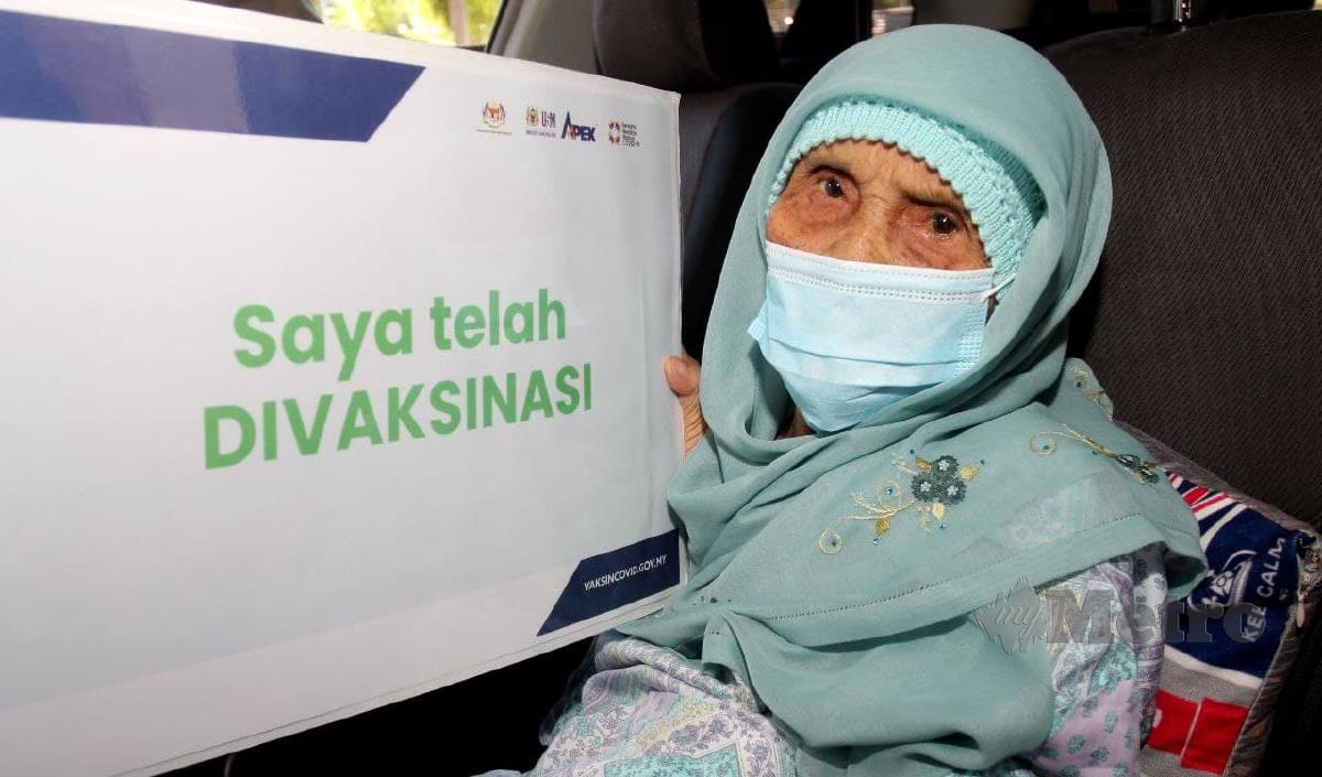 WARGA emas, Siti Liah Mamat, 120 tahun bergambar kenangan selepas selesai lengkap menerima dua dos suntikan vaksin secara pandu lalu di Pusat Pemberian Vaksin Khas (SPPV) Hospital Universiti Sains Malaysia (USM), Kubang Kerian di bawah Program Imunisasi COVID-19 Kebangsaan (PICK). FOTO NIK ABDULLAH NIK OMAR