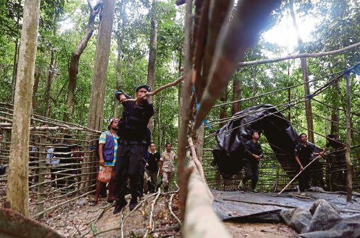 PASUKAN keselamatan memeriksa kem yang ditinggalkan di hutan di selatan Thai, semalam. 
