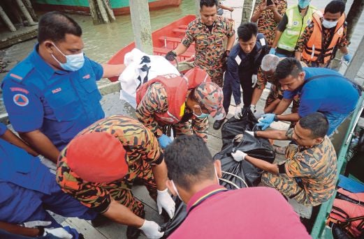 ANGGOTA penyelamat mengangkat mayat mangsa bot karam di Markas Utama Mencari dan Menyelamat (SAR) di UP Berhad Perhentian Feri Ladang Sungai Bernam.