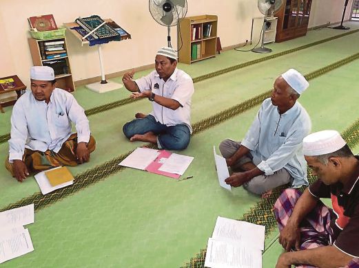 Othman (dua dari kiri)   berbincang dengan  imam dan ahli jawatankuasa masjid.