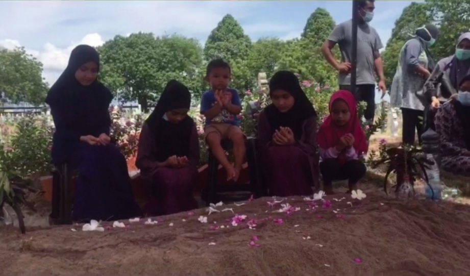 LIMA anak  Zuriana  mengaminkan doa selepas pengebumian ibu mereka di Tanah Perkuburan Islam Bagan Jermal, semalam.