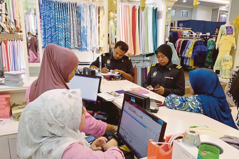    Penguat Kuasa KPDNKK Negeri Sembilan memeriksa   butik tudung yang sebelum ini menjual tudung pada harga  yang sama selepas  GST pada kadar sifar.  