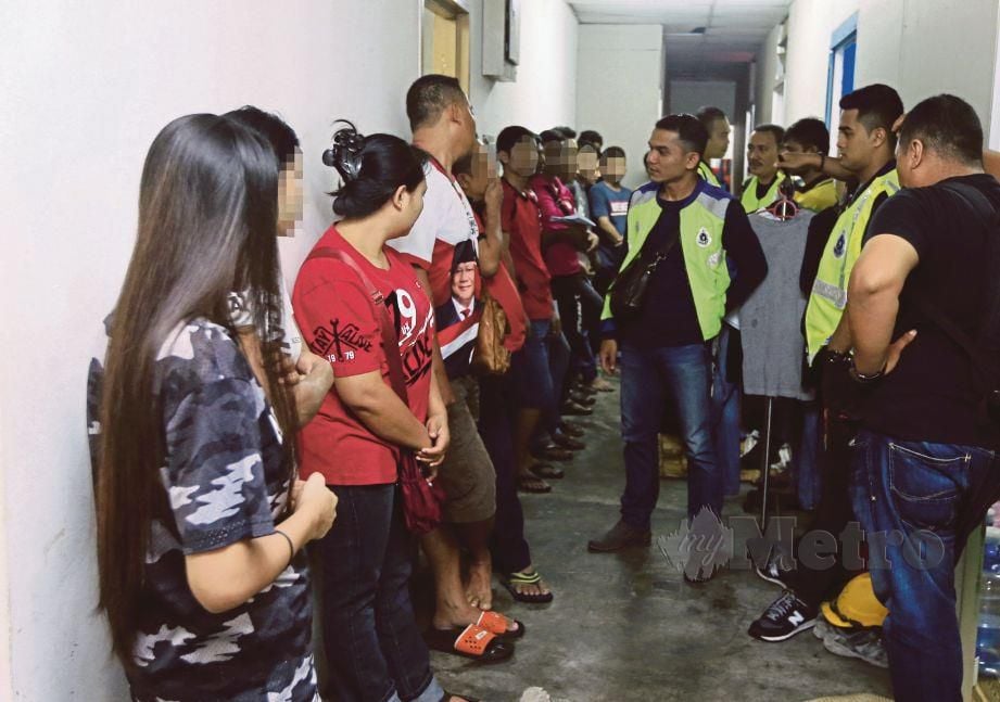 SEBAHAGIAN pekerja warga asing yang ditahan di asrama mereka  di Jalan Radin Tengah, Bandar Baru Sri Petaling.