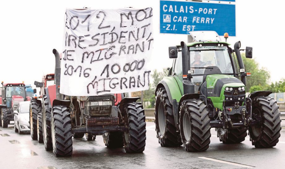 PETANI, pekerja pelabuhan, pemandu lori, pemilik kedai dan penduduk berganding bahu memprotes situasi pendatang di Calais. - Reuters 