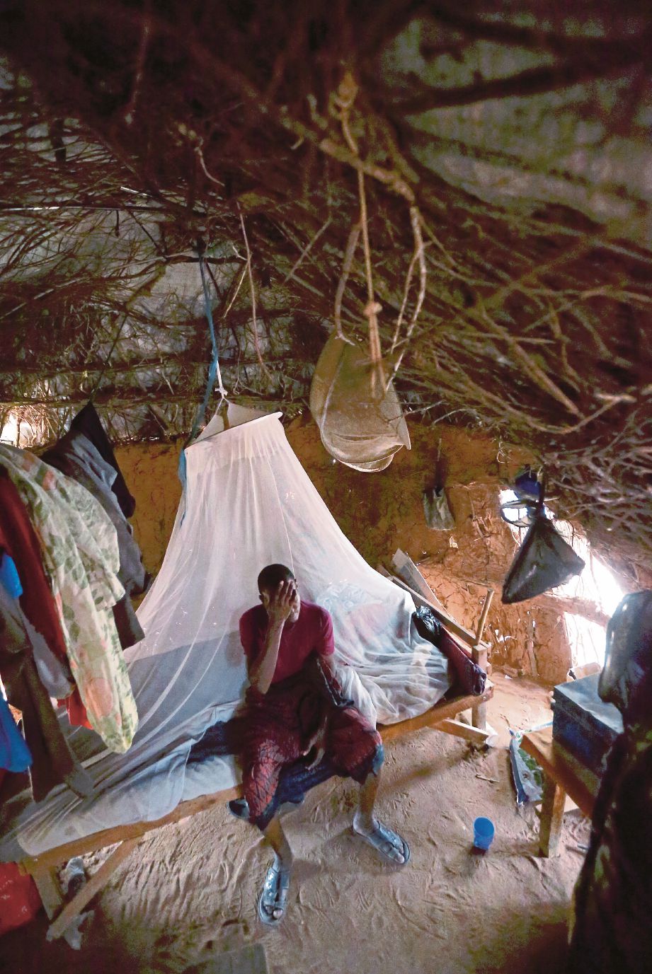 ABDUL Kareem berehat di dalam pondok yang diperbuat daripada ranting kayu, daun dan kain di Kem Dadaab.