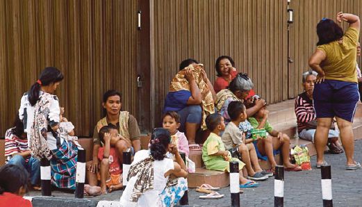 SEKUMPULAN pengemis bersama anak-anak mereka berehat di satu kawasan di Jakarta.    