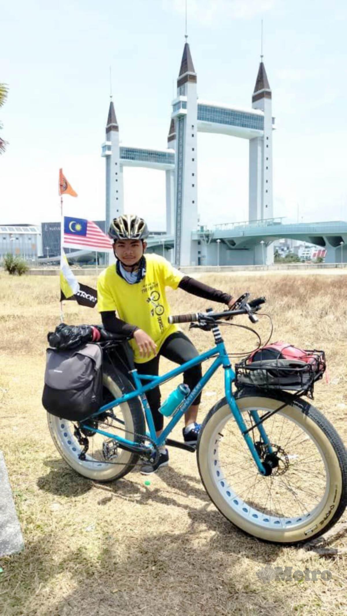 MUHAMMAD Ammar   merakamkan gambar berlatar belakang Jambatan Angkat di Kuala Terengganu, Terengganu.