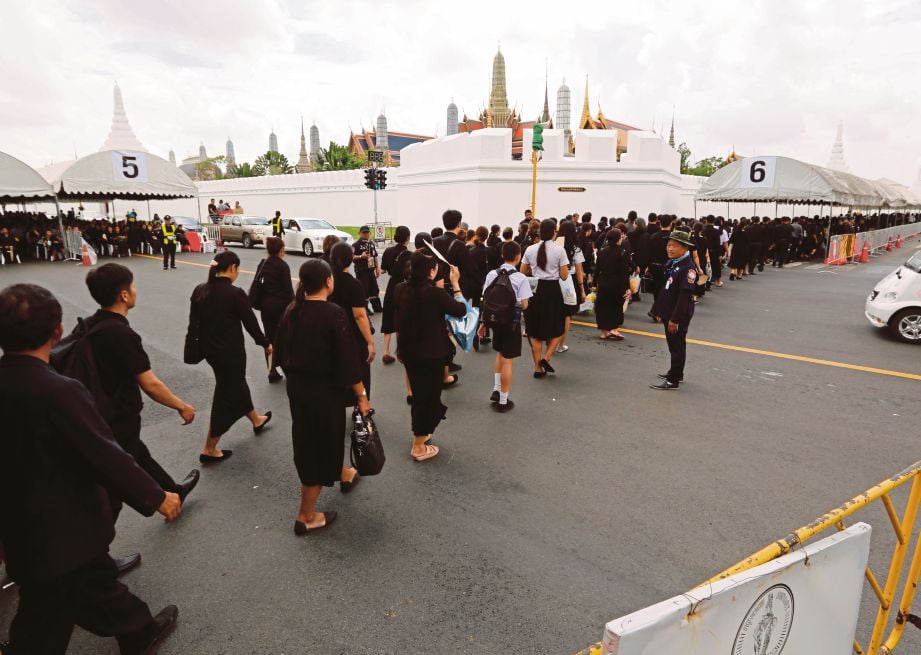 ORANG ramai yang memakai baju hitam berbaris untuk masuk ke istana bagi memberi penghormatan terakhir kepada Raja Bhumibol Adulyadej. - EPA