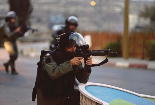 SEORANG tentera Israel mengacu senjatanya untuk menembak penduduk Palestin yang menunjuk perasaan berhampiran penempatan Yahudi di Ramallah, Tebing Barat, semalam. 