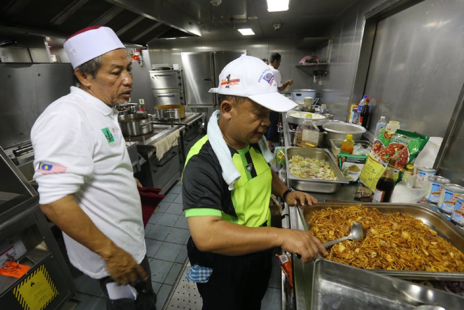 Jamuliddin (kiri) meninjau persiapan hidangan untuk sukarelawan.