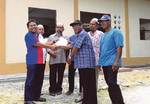 OTHMAN (kiri) menyerahkan baki cek bernilai RM 35,000 kepada Abdul Rahim.