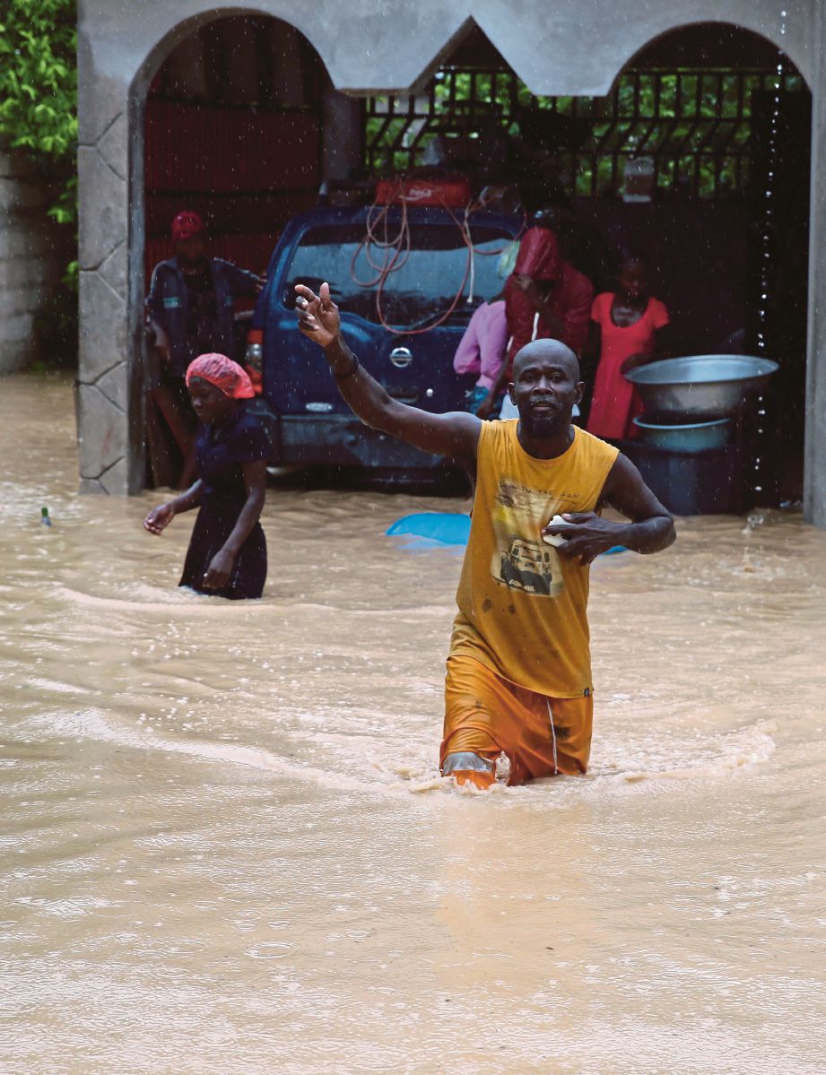 SEORANG lelaki meredah banjir di Fonds Parisiens, barat Haiti.  Banjir berlaku selepas taufan Matthew membadai negara itu lewat kelmarin.  