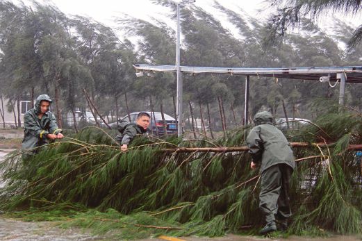 ORANG ramai berusaha mengalihkan dahan kayu dari jalan di Maoming, wilayah Guangdong yang dibadai Taufan Mujigae.