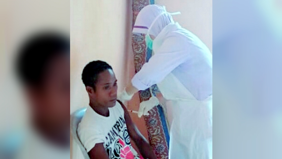 PENDUDUK Orang Asli suku Batek di Kampung Kuala Koh, dekat Gua Musang, menunggu giliran menerima suntikan vaksin daripada petugas khas Jabatan Kesihatan Gua Musang. FOTO Ramli Ibrahim
