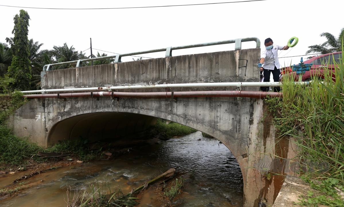 Pegawai Badan Kawalselia Air Negeri Johor (BAKAJ) mengambil sampel air sungai yang dilaporkan dicemari bahan kimia berpunca dari sebuah stor haram di Kampung Baru Sengkang, Kulai, Johor. FOTO NUR AISYAH MAZALAN