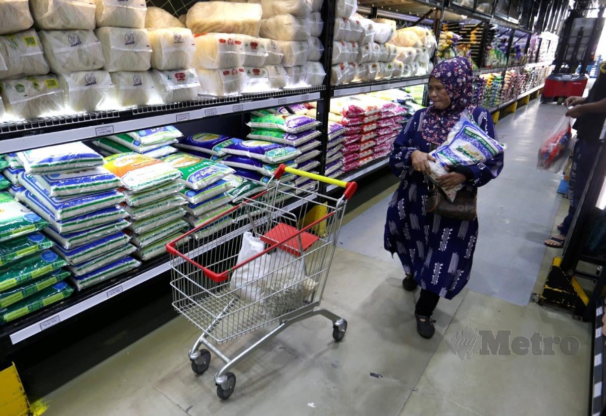 PENGUNJUNG memilih beras yang dijual di sebuah pasar raya ketika tinjauan di Wangsa Maju, Kuala Lumpur. FOTO MOHAMAD