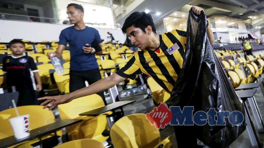 MENTERI Belia dan Sukan, Syed Saddiq mengutip sampah di tempat duduk penonton selepas perlawanan bola sepak Final Shopee Piala FA 2018 di Stadium Nasional Bukit Jalil. FOTO Hafiz Sohaimi