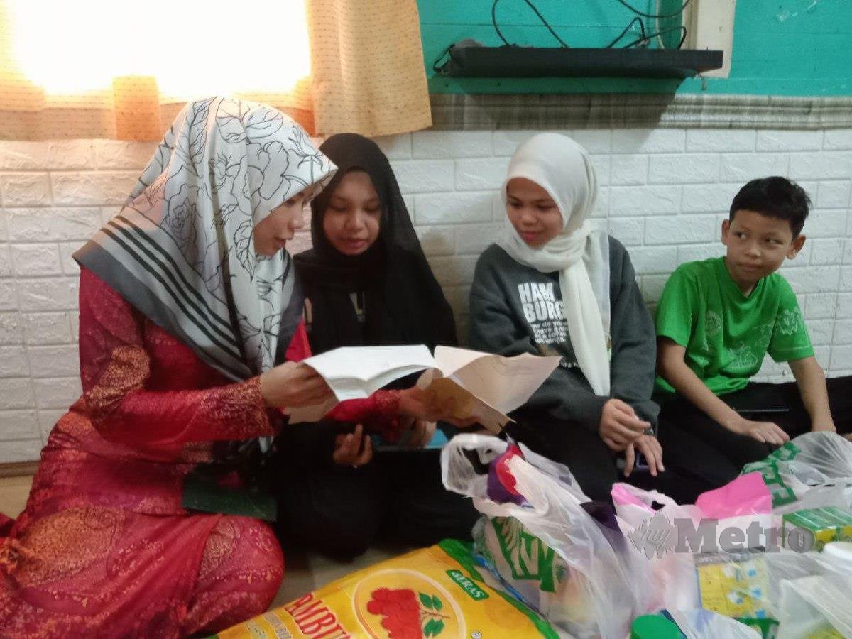 Maznah (kiri) menunjukkan kad rawatan Talaesmia kepada anak-anaknya. FOTO OMAR AHMAD