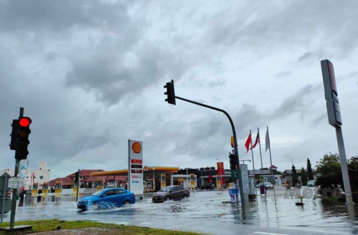 Air yang naik di kawasan Lebuhraya Sultanah Bahiyah susulan hujan lebat menyebabkan pengguna jalan raya terpaksa memperlahankan kenderaan mereka. FOTO IHSAN Pembaca