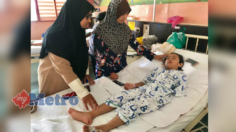 NUR Zulaika Khumaira Zulkifli, 7, terlantar di wad Hospital Sultanah Nur Zahirah selepas tangannya terputus akibat baju dipakainya terbelit dalam rim tayar motosikal. Dia ditemani ibunya, Rohidayu Siup@Yusof. FOTO Ghazali Kori