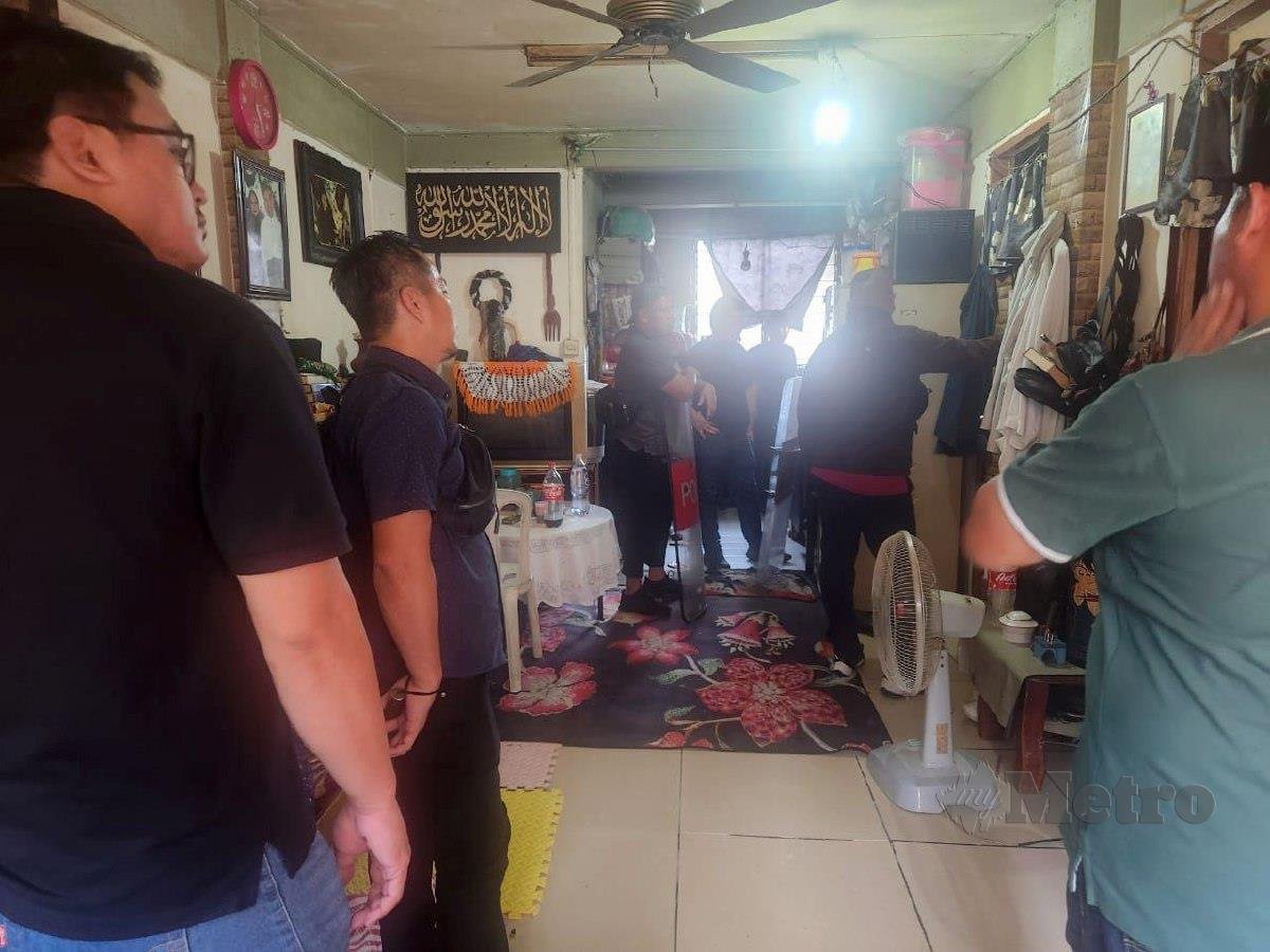 Pasukan polis dalam proses memujuk suspek yang mengurung ibunya di dalam bilik di sebuah rumah di Taman Jaya Diri, Manggatal. FOTO Ihsan PDRM