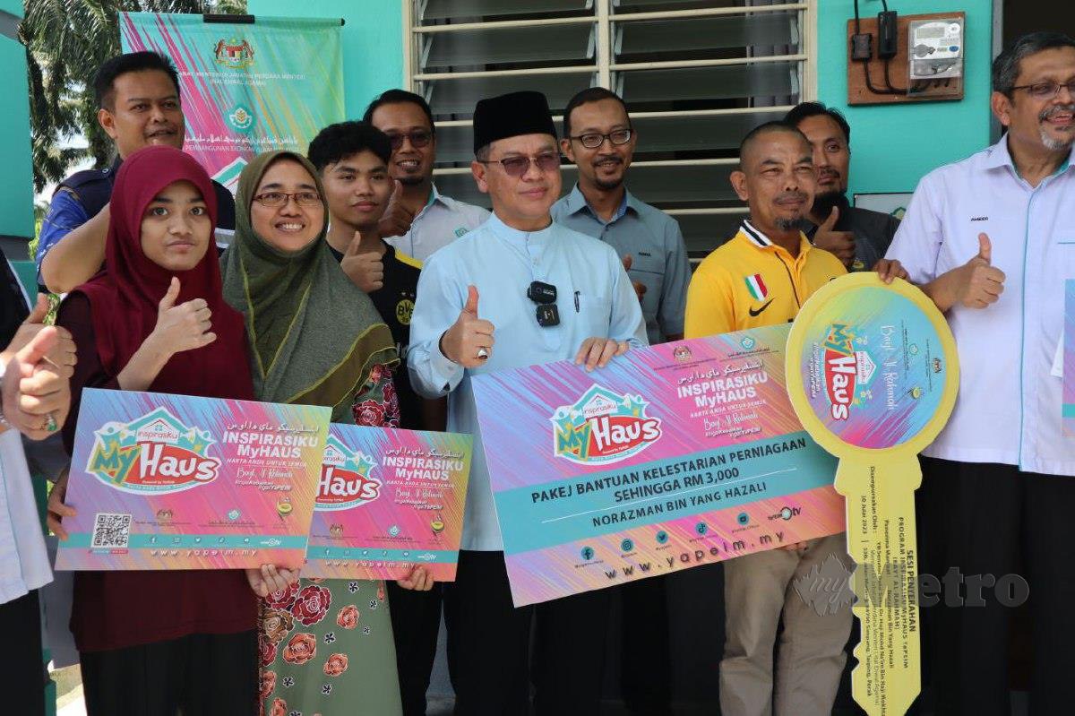 Mohd Na'im (tengah) menyerahkan Pakej Bantuan Lestari Perniagaan bernilai RM3,000 inisiatif Inspirasiku MyHAUS YaPIEM kepada Norazman (berbaju kuning, dua kanan). FOTO MUHAMAD LOKMAN KHAIRI