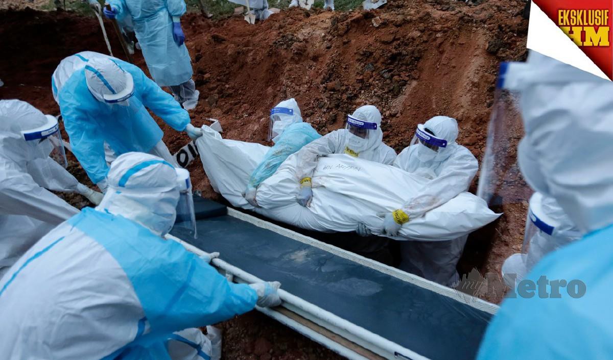 Sebahagian petugas kesihatan melakukan proses pengebumian jenazah yang meninggal disebabkan wabak COVID-19. FOTO AIZUDDIN SAAD