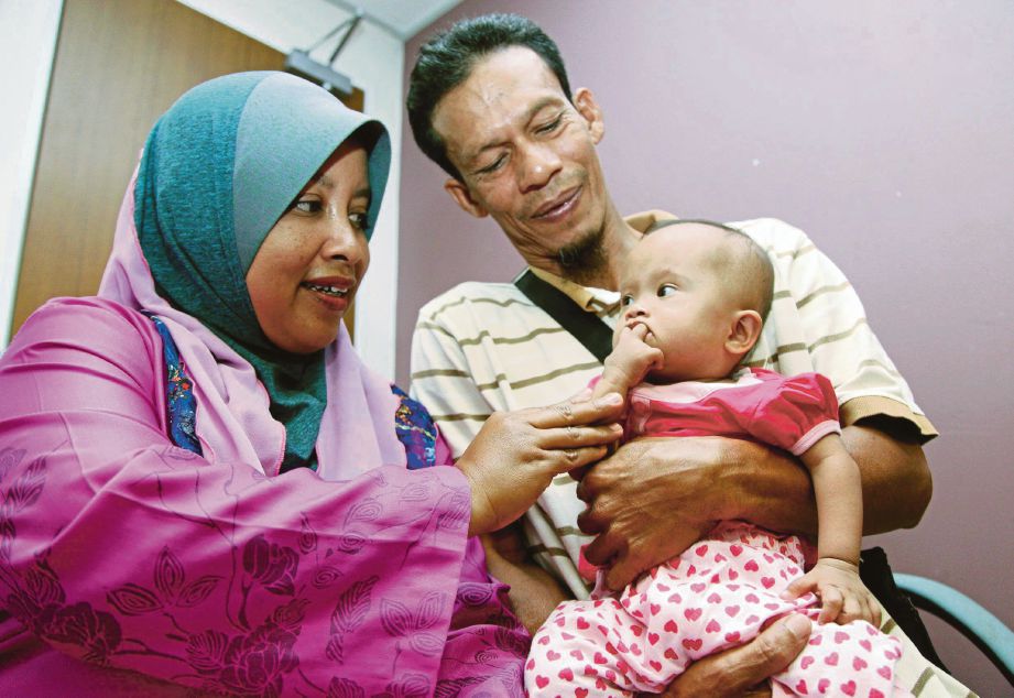 FARIDAH dan  Mohd Syukri bersama Nurul Nasuha   yang menghidap penyakit jantung berlubang sejak kecil.