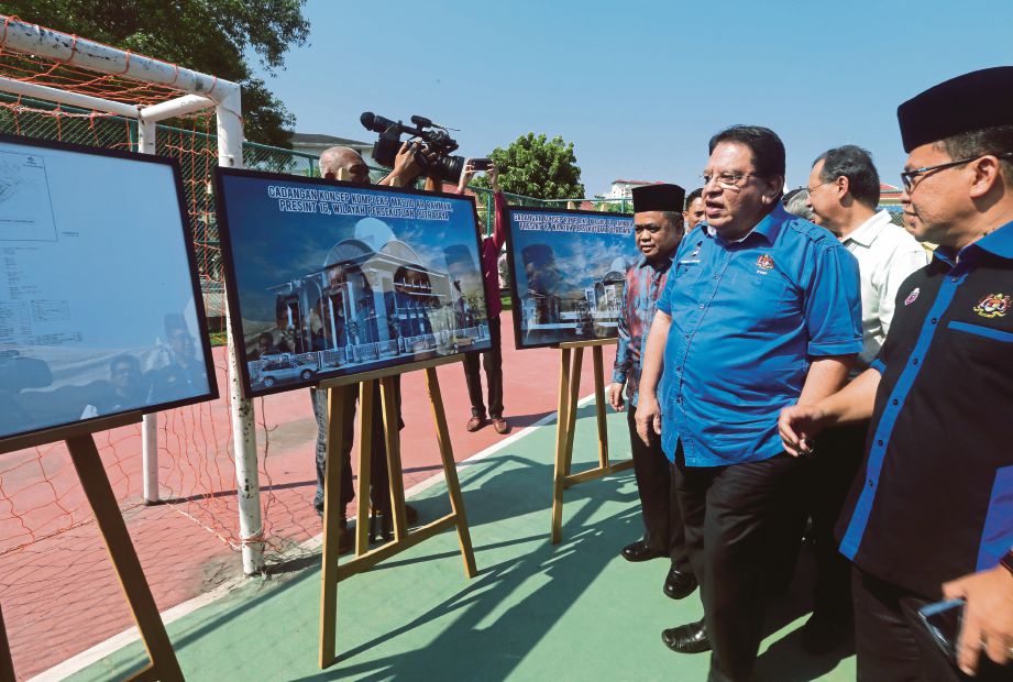 CALON BN Parlimen Putrajaya Ku Nan melihat lakaran pelan sekolah rendah agama ketika merasmikan majlis pecah tanah di Presint 16, Putrajaya.